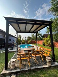 a pavilion with a table and benches and a pool at A Famosa Villa 62 with Private Swimming Pool in Kampong Pulau Sebang +17 photos