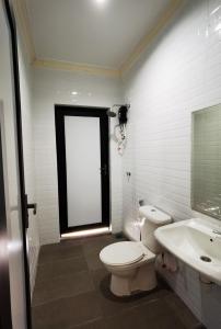 a white bathroom with a toilet and a sink at A Famosa Villa 62 with Private Swimming Pool in Kampong Pulau Sebang