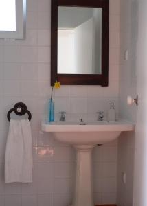 a bathroom with a sink and a mirror at Casa do Hibisco in São João do Estoril