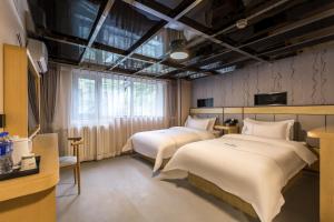 Llit o llits en una habitació de Dequan Hotel Chaoyang Park Branch Coffee fruits, snacks a gym and a laundry room are provided for free in the lobby