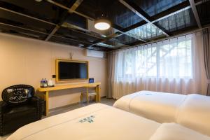 Televisor o centre d'entreteniment de Dequan Hotel Chaoyang Park Branch Coffee fruits, snacks a gym and a laundry room are provided for free in the lobby