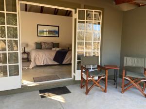 a bedroom with a bed and a table and chairs at Murchison View Cottage in Gravelotte +20 photos