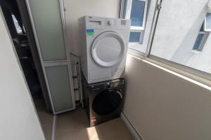 a washing machine in a room with a window at Mat Leo Homestay at MRT Kajang in Kajang +7 photos