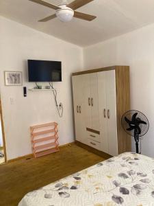 a bedroom with a bed and a flat screen tv at cabaña NFF in Punta Del Diablo