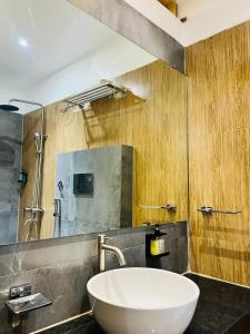 a bathroom with a white sink and a shower at Hotel Wood Inn in Hoshangābād