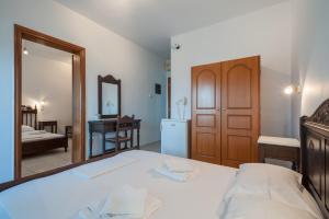 a bedroom with a bed and a mirror at Evgatis Hotel in Kondiás