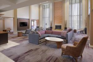 a lobby with a couch and chairs and a tv at Courtyard by Marriott Houston Northwest in Houston