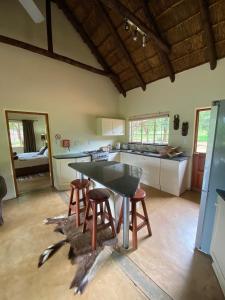 una cucina con tavolo e sgabelli in una stanza di Murchison View Cottage a Gravelotte