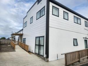 a large white building with a ramp next to it at The White House Apartment in Tokoroa