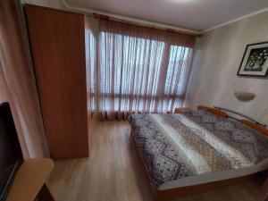 Un dormitorio con una cama y una ventana grande. en Apartment Larissa, en Pomorie