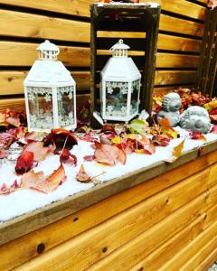 two lanterns on a table with leaves and lights at Altstadtpension am Dom in Erfurt
