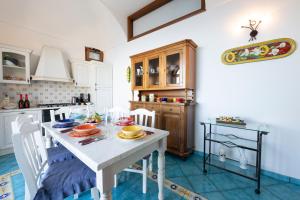 a kitchen with a white table with plates on it at La Cascina - Villa Nenno in Conca dei Marini