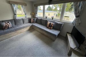 a living room with a couch and a tv at West Lawn 47 Haggerston Castle Paddock Views in Berwick-Upon-Tweed