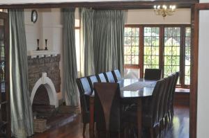 a dining room with a table and chairs and a fireplace at The Breakers at St James, Cape Town in St. James