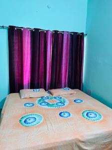 a large bed with flowers on it with purple curtains at Prayag Homestays Cheoki in Prayagraj