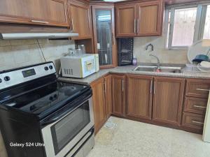 een keuken met een fornuis en een magnetron bij Lukanda Apartment Feel at Home in Amman +11 foto's