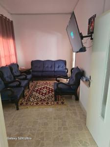 een woonkamer met banken en een flatscreen-tv bij Lukanda Apartment Feel at Home in Amman