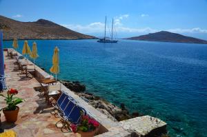 a boat in the water with chairs and umbrellas at Villa Hiona in Halki