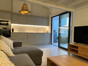 a living room with a couch and a television at Casa Cordoama in Bordeira