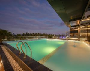 a pool on the roof of a building at night at Starcity Bayfront Nha Trang Hotel in Nha Trang