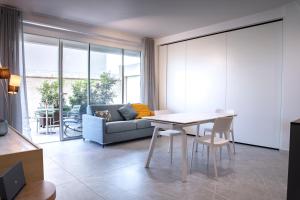 una sala de estar con una mesa y un sofá en Appartamento Guglielmo 2, en Oristano