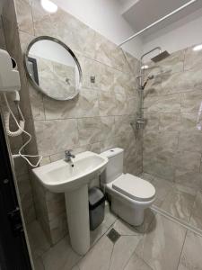 a bathroom with a toilet and a sink and a mirror at Destination Central Room 2 in Tirana