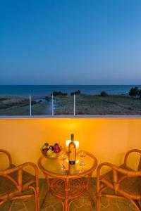 a table with a bottle of wine and a bowl of fruit at Evgatis Hotel in Kondiás