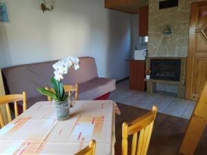 a dining room table with a vase of flowers on it at Domki Pod Kasztanem in Dąbki