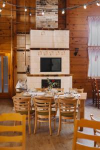 a dining room with a table and chairs and a fireplace at Karczma Taberska in Kolesin