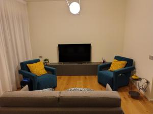 a living room with two blue chairs and a flat screen tv at Davila Luxury Home in Padova