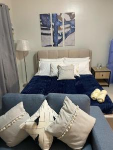 a bedroom with a bed and a couch with pillows at Cozy and Affordable Deluxe Condo near Puerto Princessa Airport in Puerto Princesa City