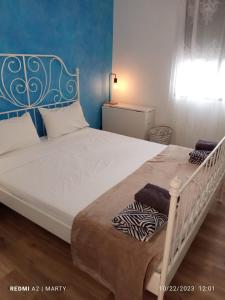 a bedroom with a white bed with a blue headboard at Casa Tropical in Salobreña