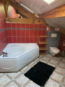 a bathroom with a white tub and a toilet at Le Nid des Bois - Maison familiale au calme entre forêt et rivière in Albertville +24 photos