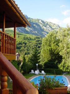 a balcony of a house with a pool and a mountain at Hotel Picos de Europa in Arenas de Cabrales