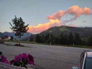 a view of a road with a mountain with smoke at Ferienunterkunft Bergluft in Balderschwang