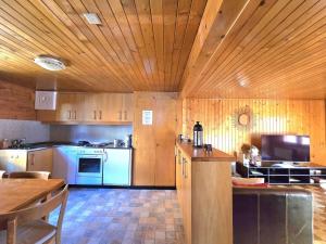 a kitchen with wooden walls and a wooden ceiling at Appartement "Le Ver Luisant" à Saint-Martin, Val d'Hérens, Valais in Saint-Martin +23 photos