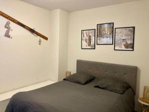 a bedroom with a bed with four pictures on the wall at Les sybelles in La Chal +25 photos