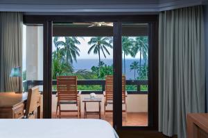 ein Schlafzimmer mit Bett und Blick auf das Meer in der Unterkunft Renaissance Koh Samui Resort & Spa in Lamai