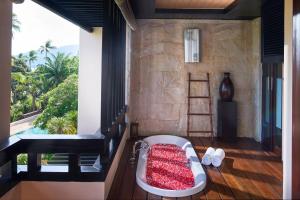 Zimmer mit einer Badewanne auf einem Balkon mit Aussicht in der Unterkunft Renaissance Koh Samui Resort & Spa in Lamai