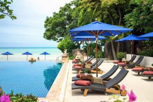 einen Pool mit Liegestühlen und Sonnenschirmen am Meer in der Unterkunft Renaissance Koh Samui Resort & Spa in Lamai