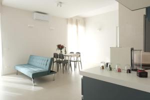 a living room with a blue chair and a table at Temples and Sea view Apartment in Agrigento