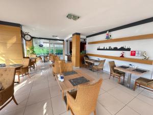 a restaurant with tables and chairs and a clock on the wall at Lounge Hotel in Tuzla