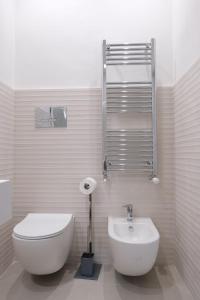 a white bathroom with a toilet and a sink at Temples and Sea view Apartment in Agrigento +13 photos
