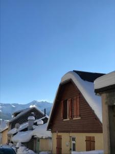 a house covered in snow with mountains in the background at duplex neuf 3etoiles in Le Mont-Dore +4 photos