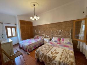 a bedroom with two beds and a chandelier at Finca Los Olivos - Grupo Berna in Ses Salines +13 photos