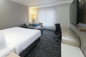 a hotel room with a bed and a couch at Courtyard Monterrey Airport in Monterrey