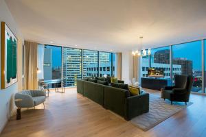 a living room with a couch and large windows at The Laura Hotel, Houston Downtown, Autograph Collection in Houston