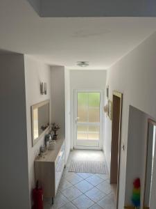 a white bathroom with a sink and a mirror at Holiday Home Sea & River Pearl in Komin