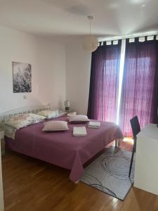 a bedroom with a large bed with purple sheets at Holiday Home Sea & River Pearl in Komin