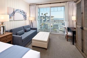 une chambre d'hôtel avec un lit, un canapé et un bureau dans l'établissement Vespera Resort on Pismo Beach, Autograph Collection, à Pismo Beach